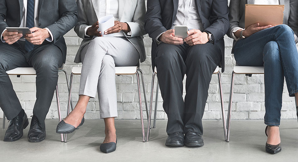 People sitting in a row wearing suits