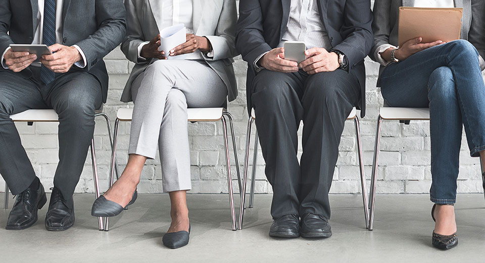 People sitting in a row wearing suits