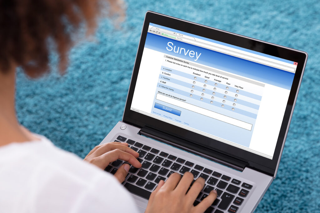 Picture of a laptop with someone filling out an online survey.
